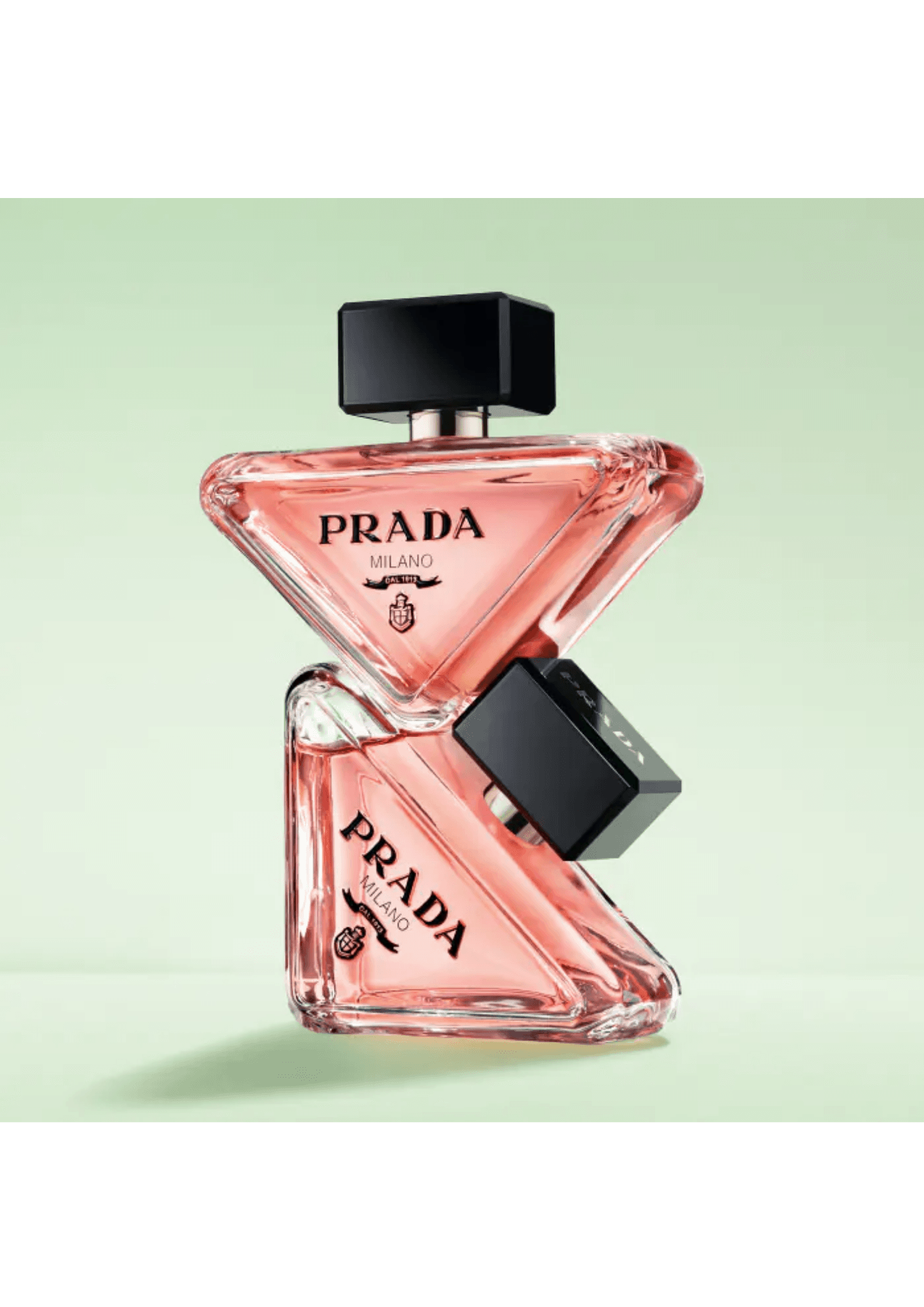 Deux flacons Prada Paradoxe empilés sur fond vert amande